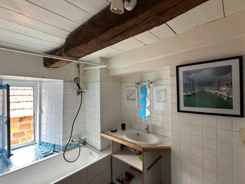 un bagno con lavandino, vasca e finestra di Ty an Holen Maison de Pêcheur à 300 m de la mer a Piriac-sur-Mer