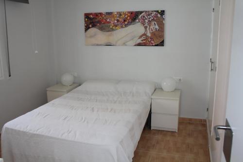 トレモリノスにあるVictoria del Sol IIの白いベッドルーム(ベッド1台付)が備わります。壁には絵画が飾られています。