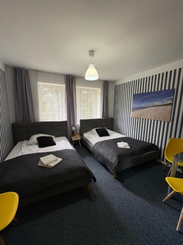 a bedroom with two beds and a painting on the wall at Great Polonia Beach & Molo in Puck