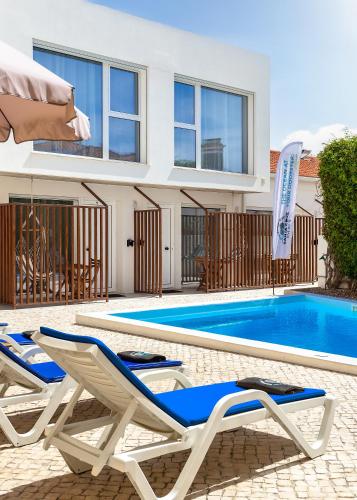 a pair of lounge chairs next to a swimming pool at Santa Cruz Dive House - PADI Centre in Santa Cruz