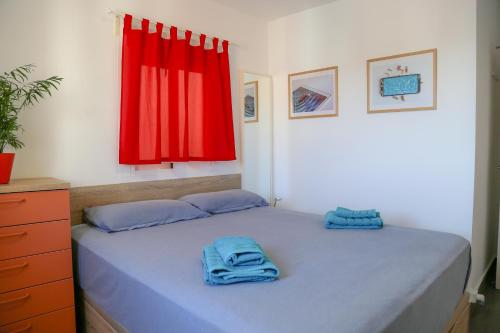 sypialnia z łóżkiem z niebieskimi ręcznikami w obiekcie Apartment Calle Larga w mieście Fuengirola