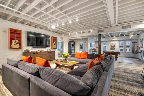 a large living room with a couch and a piano at Skyline Suite with Penthouse & Rooftop Deck 6BR by Maddox Hotel in Nashville