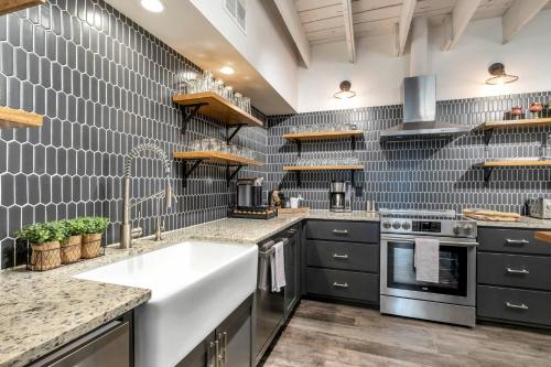 a kitchen with a sink and a stove at Skyline Suite with Penthouse & Rooftop Deck 6BR by Maddox Hotel in Nashville