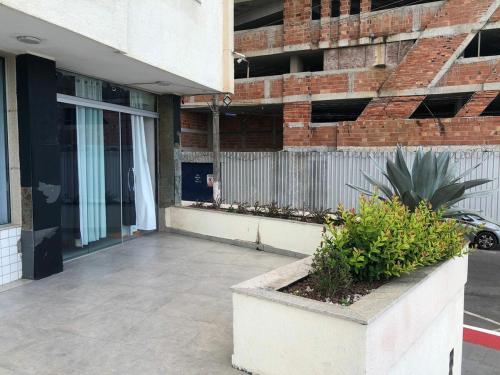 a building with a porch with a plant at Apartment Pé na Areia - Guarapari in Guarapari