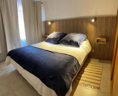 a bedroom with a large bed with blue sheets and pillows at Depto centrico soñado in San Martín de los Andes