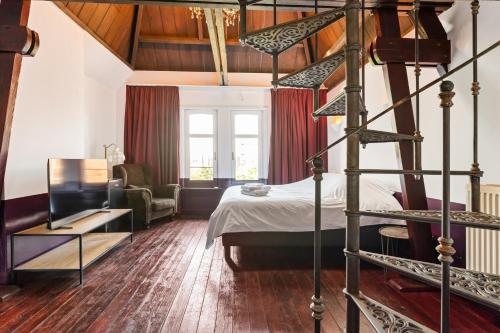 a bedroom with a bed and a spiral staircase at B&B Baron Osy Suite Four Garden in Antwerp