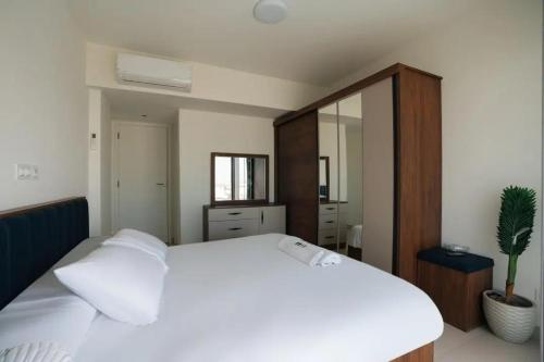 a bedroom with a white bed and a mirror at Marassi Faya 3BR Retreat in El Alamein