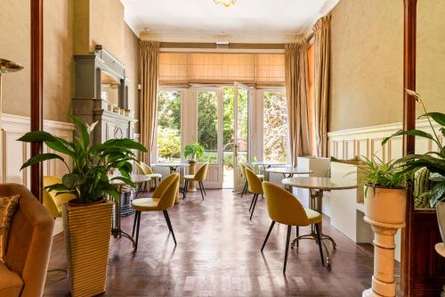 a restaurant with tables and chairs and plants at B&B Baron Osy Suite Four Garden in Antwerp