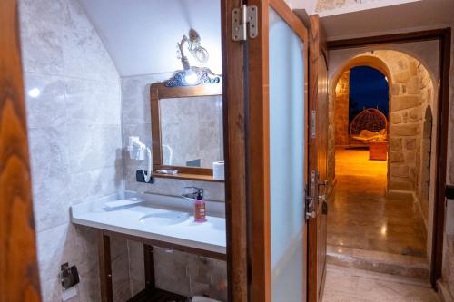 Kasr-i Divan Hotel في ماردين: حمام مع حوض ومرآة وممر