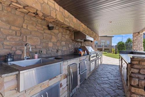 a kitchen with a sink and a stone wall at Majesty Estate in Salt Lake with Private Pool and Sport Court in Draper