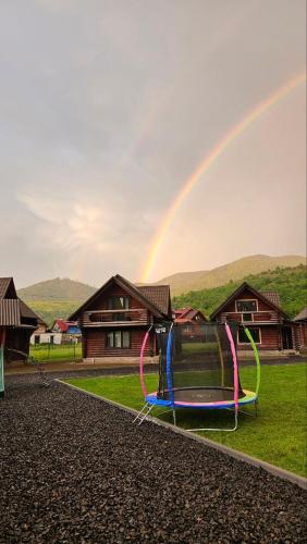 a rainbow over a playground with a swing at Котеджі Карпати Fest in Mizhhirʼʼya