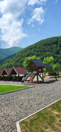 a picnic shelter with a picnic table and a wooden bench at Котеджі Карпати Fest in Mizhhirʼʼya