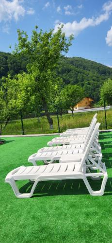 a row of white chairs on a green field at Котеджі Карпати Fest in Mizhhirʼʼya