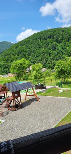 a picnic table and bench with a mountain in the background at Котеджі Карпати Fest in Mizhhirʼʼya