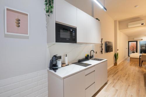 a white kitchen with a sink and a microwave at Bilbao Loft Apartments in Bilbao