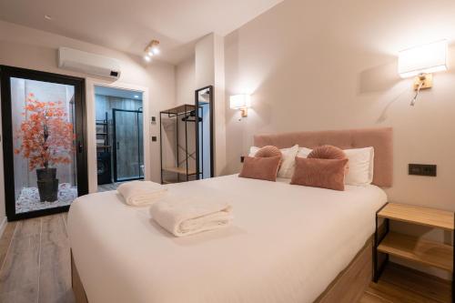 a bedroom with a large white bed with towels on it at Bilbao Loft Apartments in Bilbao