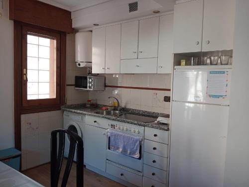 a kitchen with white cabinets and a white refrigerator at Anguiano Habitaciones rurales con baño privado in Anguiano