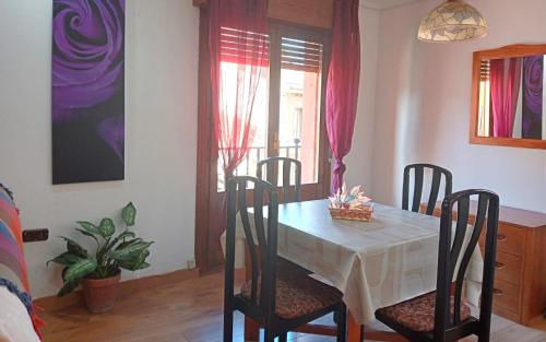 a dining room with a table with chairs and a window at Anguiano Habitaciones rurales con baño privado in Anguiano