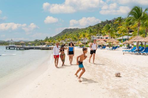a group of people playing soccer on a beach at St. James's Club Resort - All Inclusive in English Harbour Town