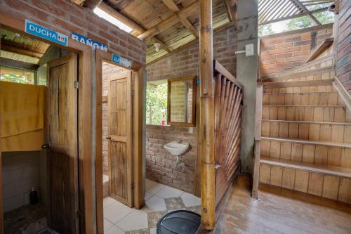 a bathroom in a house with a brick wall at Hostal Pakay in Tena