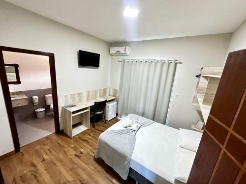 a hospital room with a bed and a mirror at Pousada Recanto das Cores in Penha