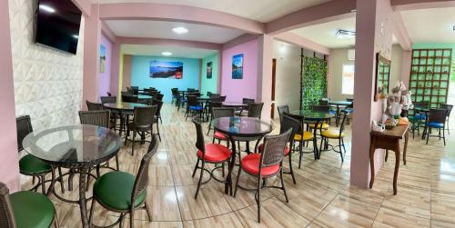 a restaurant with tables and chairs in a room at Pousada Recanto das Cores in Penha