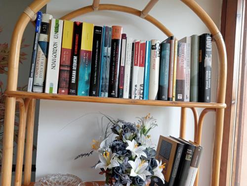 a book shelf with books and a vase of flowers at Anguiano Habitaciones rurales con baño privado in Anguiano