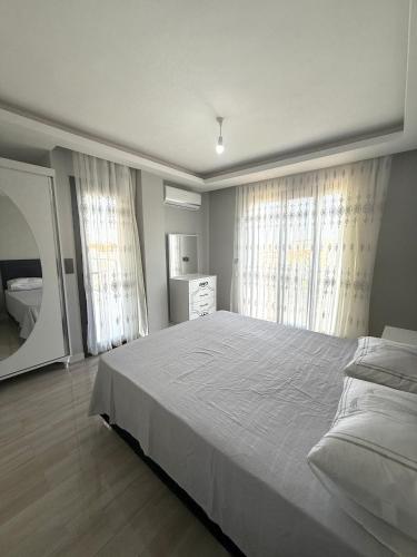 a bedroom with a large bed and two windows at Luxury Villa with Pool Near Sarimsakli Beach in Ayvalık