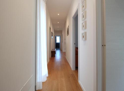 a hallway with white walls and wooden floors at Casa Delle Eriche, Colli Euganei, Pool, Wifi in Teolo