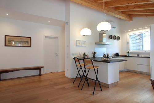 a kitchen with a counter and chairs in a room at Casa Delle Eriche, Colli Euganei, Pool, Wifi in Teolo