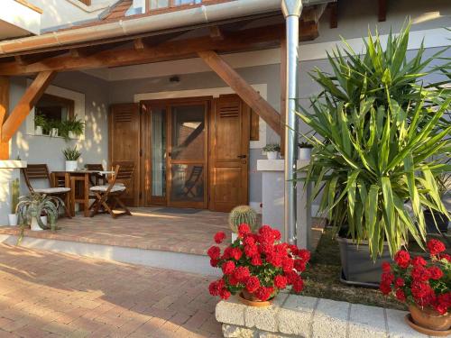 a front porch of a house with flowers and plants at Sárkányhegyi Apartman in Balatonederics