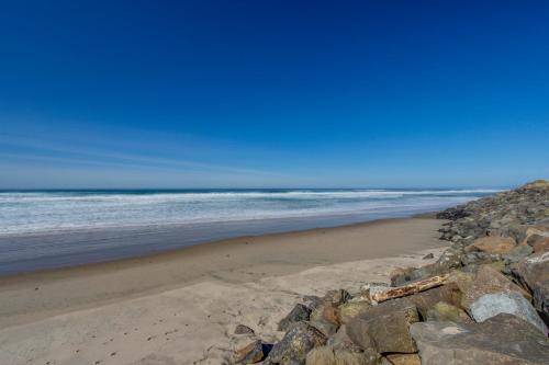 a beach with some rocks and the ocean at White Wing in Neskowin