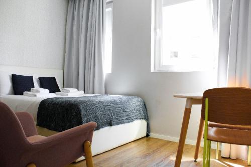a bedroom with a bed and a chair and a table at Apartamentos do Prado In Douro in Vila Real