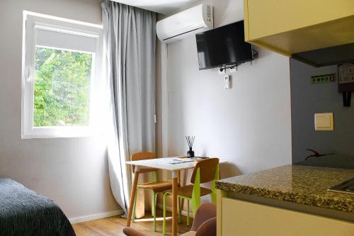 a small kitchen with a small table and a window at Apartamentos do Prado In Douro in Vila Real