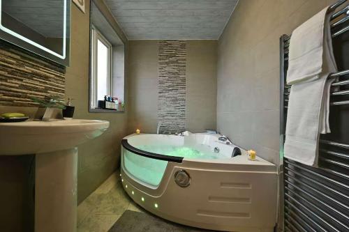 a bathroom with a tub and a sink at Wythenshawe Greenbrow Retreat in Manchester