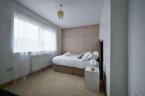 a white bedroom with a bed and a window at Wythenshawe Greenbrow Retreat in Manchester