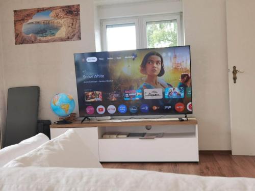 a flat screen tv sitting on a stand in a bedroom at Family-Friedndly Home with Large Garden &BBQ Grill in Dreieich