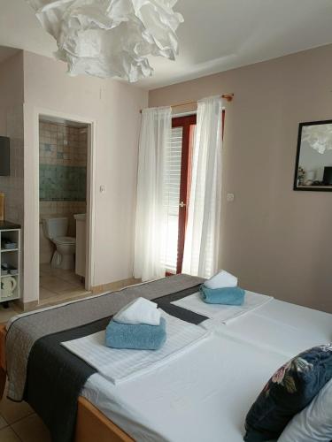 a bedroom with a large bed with two pillows on it at Agava Apartments in Sutivan