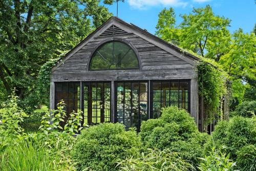 an old greenhouse in a garden with plants at Stunning Cottage in Famous KY Garden -Sleeps 2 in Prospect