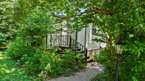 a house with a staircase in the middle of trees at Stunning Cottage in Famous KY Garden -Sleeps 2 in Prospect