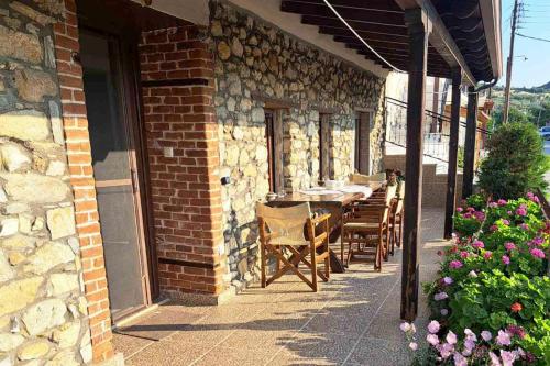 a patio with tables and chairs on a brick building at Village Stone House in Ofrínion