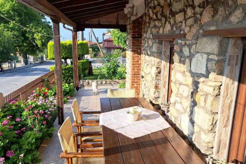 a patio with a table and chairs and a stone wall at Village Stone House in Ofrínion