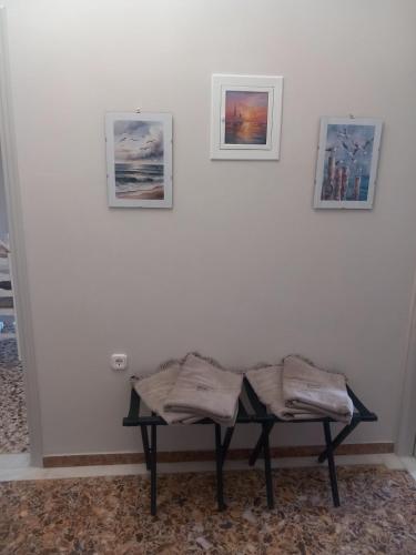 a bench in a room with three pictures on the wall at Elmar Mosaic Suites in Paralion astros