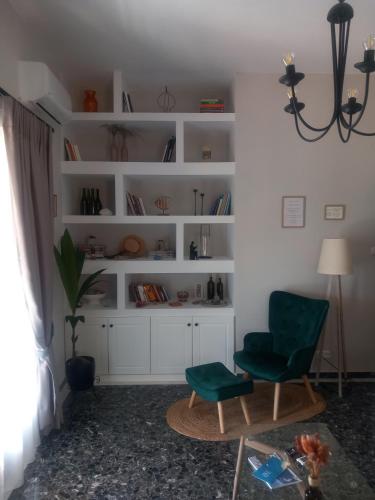 a living room with a green chair and a table at Elmar Mosaic Suites in Paralion astros