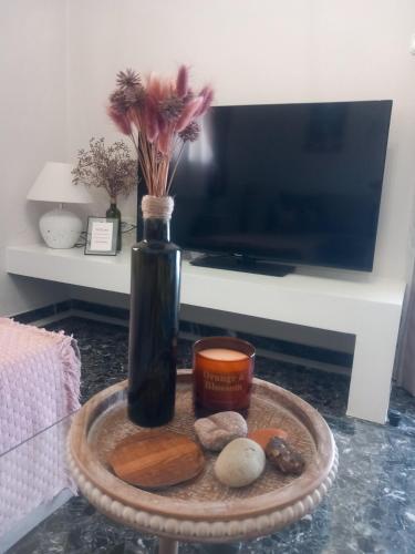 a vase with flowers and a candle on a table at Elmar Mosaic Suites in Paralion astros