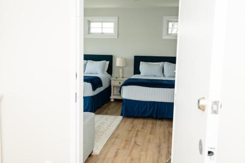 a bedroom with two beds with blue sheets at Terrace By The Sea in Ogunquit