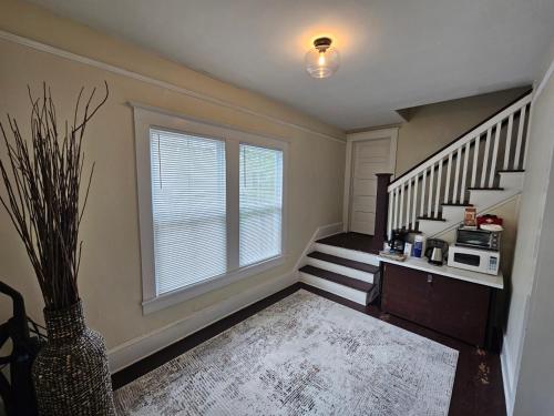 a room with a staircase with a microwave and a window at Wilmington Classic Next To Downtown in Wilmington