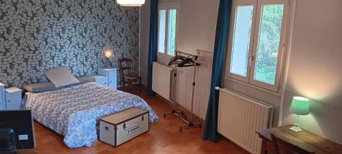 a bedroom with a bed with a blue patterned wall at Les Figuiers Bleus in Cravencères