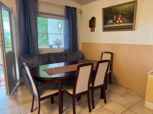 une salle à manger avec une table, des chaises et un canapé dans l'établissement Foxy burrow, à Verla
