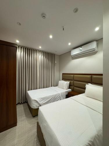 a hotel room with two beds and a window at انوار الهدى للشقق المخدومة in Al Madinah